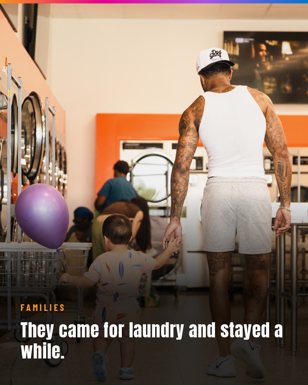 An adult holding a child’s hand inside the laundromat during the Day of Hope.